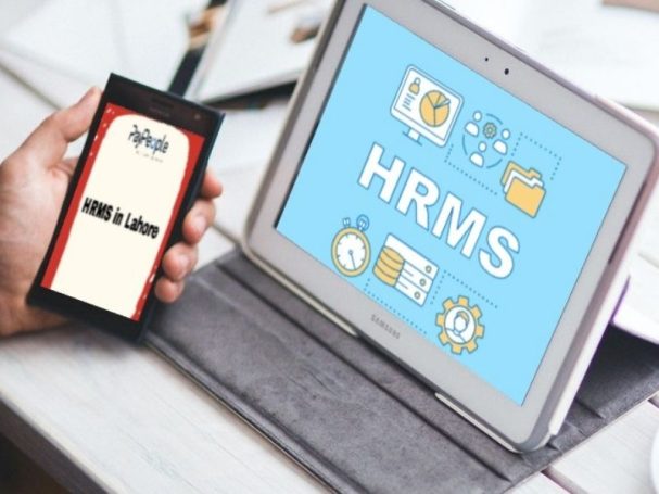 Corporate professionals in a modern office meeting using HRMS in Lahore for talent development.